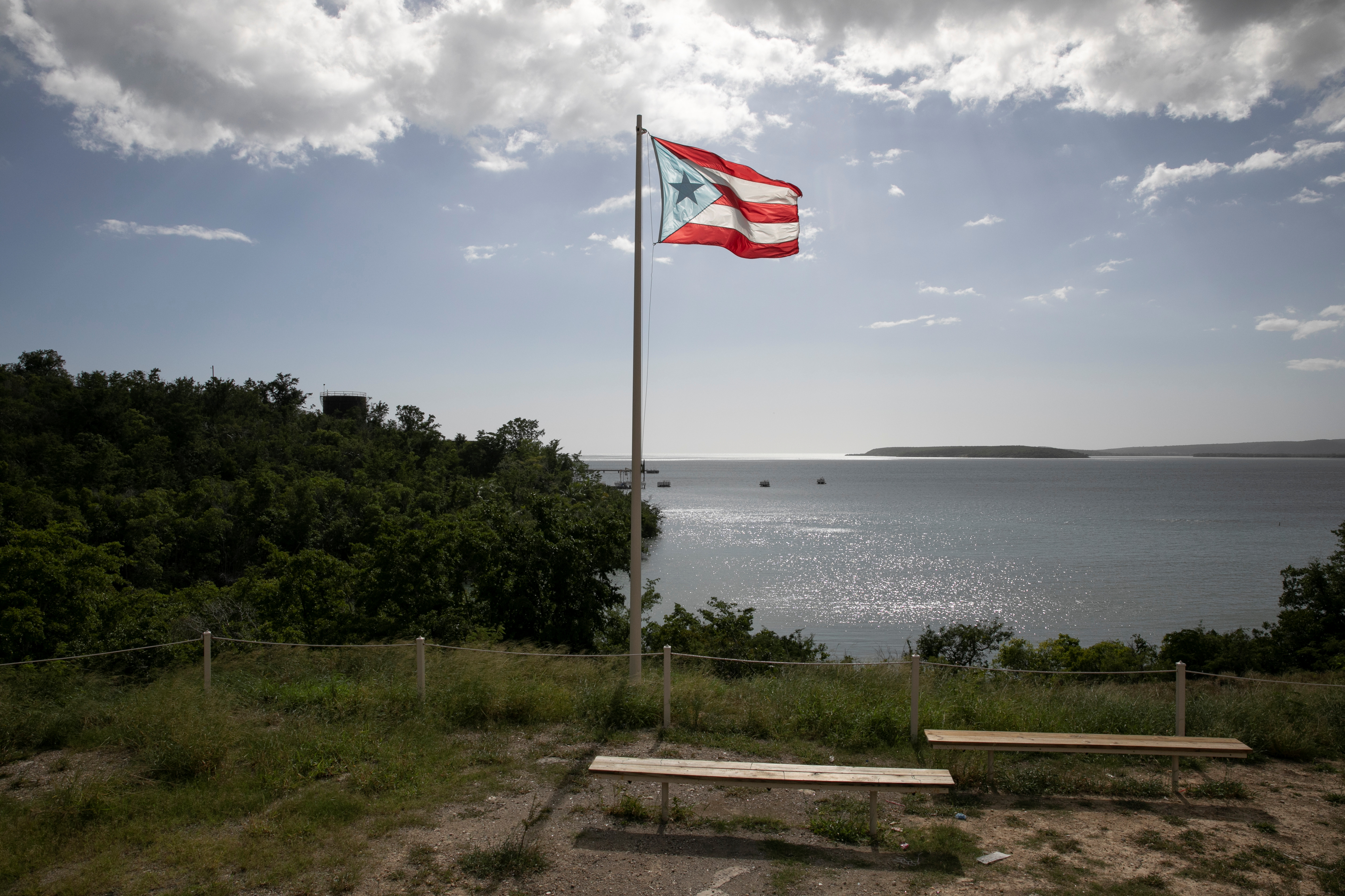A Puerto Rican flag flies in front of the bay after the earthquake in Guayanilla